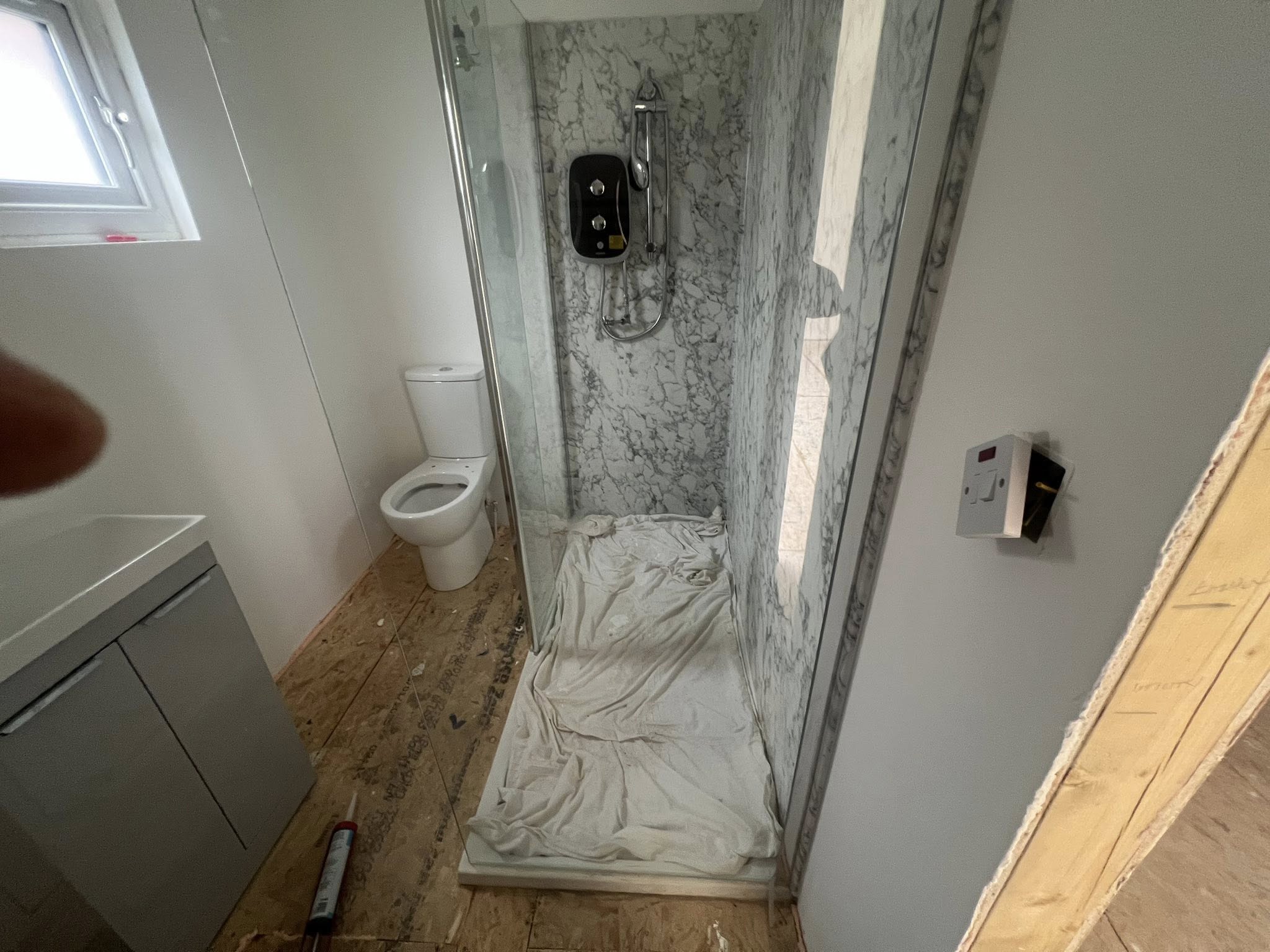 Bathroom renovation with marble shower tiling and fixtures